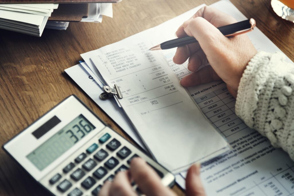 women calculating her tax return at a table - should get 123 Easy Books VAT return services to help!